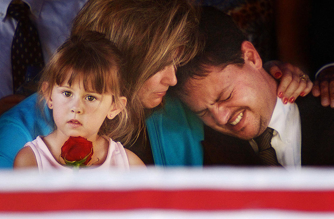 Third Place, Student Photographer of the Year - Haraz Ghanbari / Kent State UniversityGreg Owen (right) cries on the shoulder of his wife Deborah Owen, as their 4-year-old daughter Emma, holds a rose at the gravesite of Greg's father, Birmingham, Ala., Police Officer Carlos Winston Owen, June 21, 2004 at Jefferson Memorial Gardens Cemetery in Turssville, Ala. Officer Owen was one of three police officers killed June 17 as they attempted to deliver a warrant.