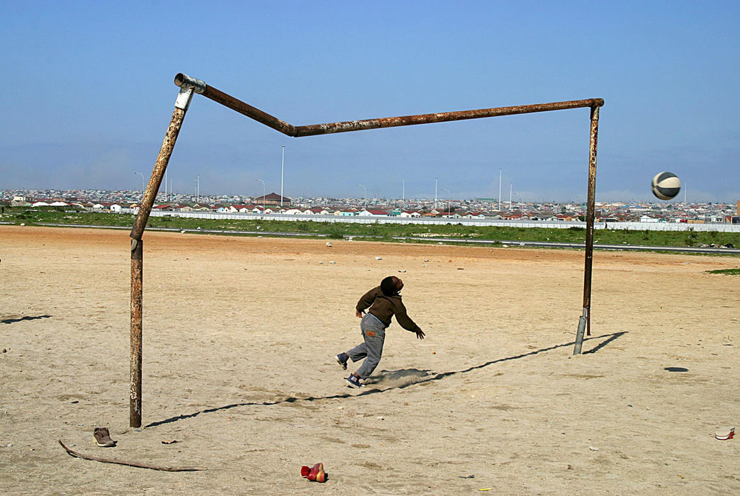 First Place, Student Photographer of the Year - Samantha Reinders / Ohio UniversityMonwabisi (7) plays on a dusty soccer pitch in Khayalitsha Township, South Africa, August 2004. Soccer is the most popular sport among township dwellers and South Africa has just been awarded the 2010 Soccer World Cup bid.  “I cannot wait for the World Cup … I think I won’t sleep until then,” says Monwabisi. 