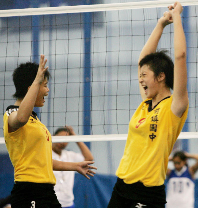 Second Place, Team Picture Story - John Kuntz / The Plain DealerYa-ling Chung (left) and Yi-ju Chen celebrate their team's second victory over the Baja California, Mexico, volleyball team.  The girls are from Kaohsiung City, Taiwan.
