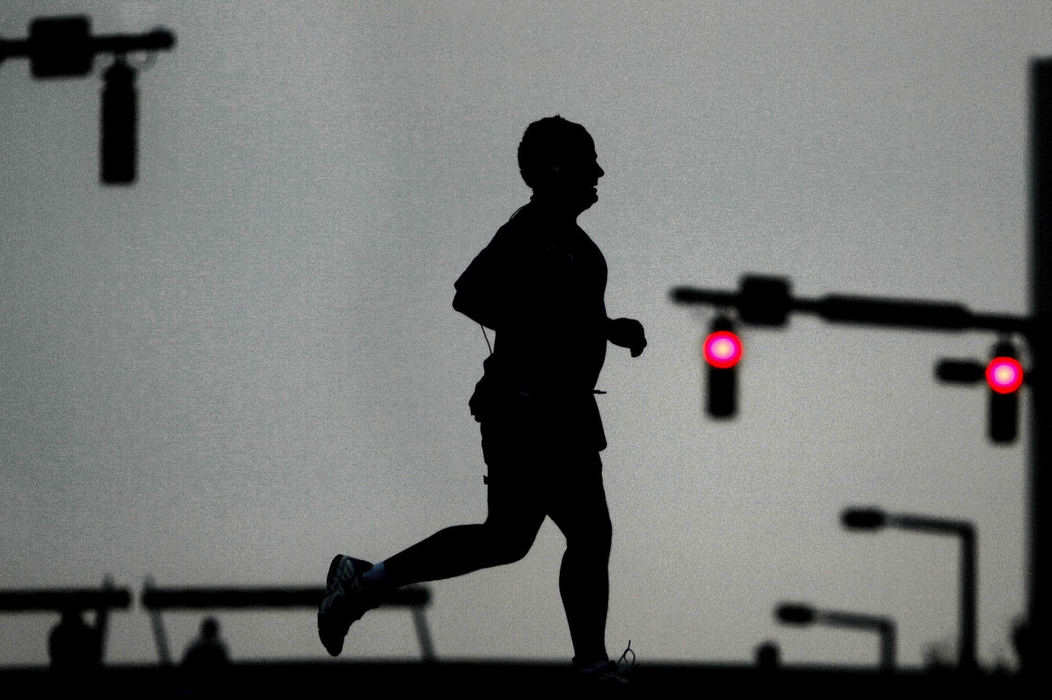 First Place, Team Picture Story - Ed Suba Jr. / Akron Beacon Journal A runner passes through the intersection of High Street and University Avenue while competing in the 2004 Road Runner Akron Marathon on October 2, 2004. 