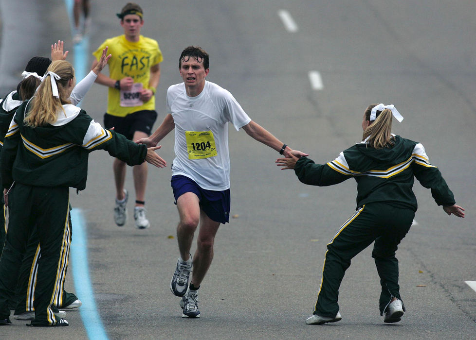 First Place, Team Picture Story - Phil Masturzo / Akron Beacon JournalSt. Vincent-St. Mary High School cheerleaders pass out high-fives to  Andrew Hegewald of Columbus as he runs along West Market Street during the 2004 Road Runner Akron Marathon on October 2, 2004. Hegweld finished in 65th place for the race.