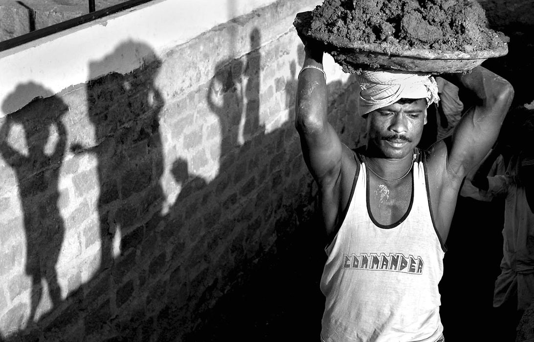 Third Place, Enterprise Feature - Craig Ruttle / The Cincinnati EnquirerAs the evening sun lay low on the horizon, laborers, mostly family members young and old, cast long shadows as they dig a deep and long pit by hand that will eventually hold a massive gasoline tank at a service station near the city of Hyderabad, India. Manual labor, performed by people many hours a day, is not uncommon in parts of India.