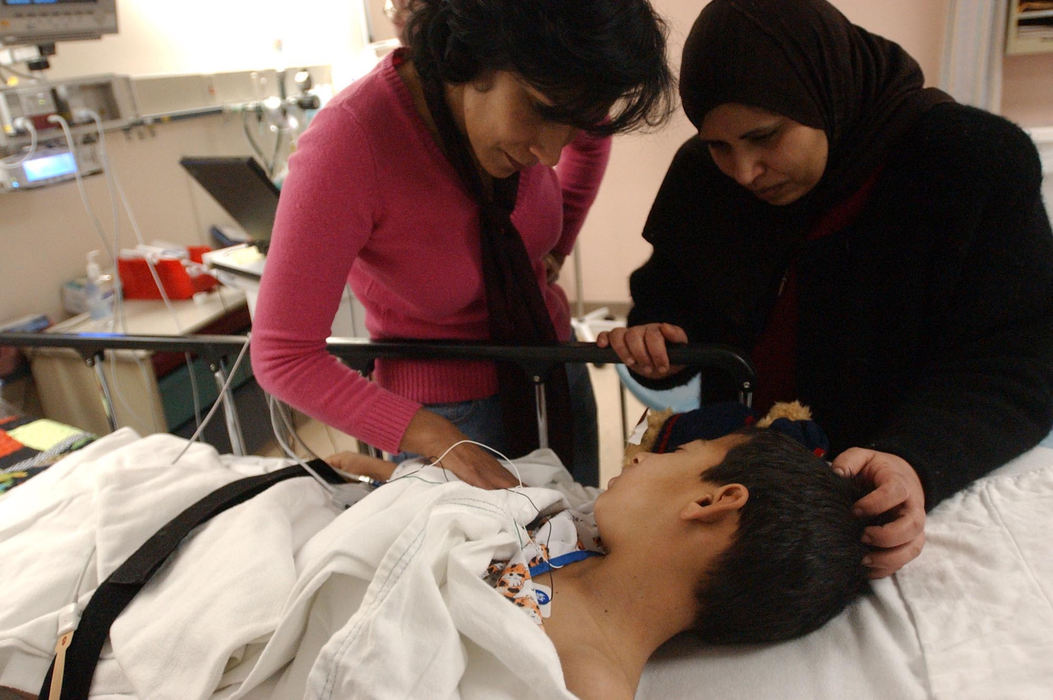 Second Place, Feature Picture Story - Karen Schiey / Akron Beacon JournalMajid Fadhil is comforted by his host mother Huda Sosebee (left) and her friend Um Talal, an Iraqi native, as he comes out of anesthesia after surgery to prepare his legs for prosthetics at Akron Children's Hospital. 
