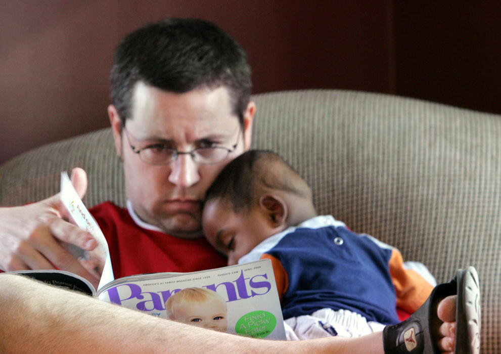 Third Place, Feature Picture Story - Chris Russell / The Columbus DispatchRodney takes some time to read about childcare issues in Parents Magazine while Bryce falls asleep on his lap.   
