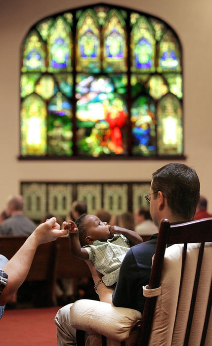 Third Place, Feature Picture Story - Chris Russell / The Columbus DispatchJim holds Bryce's hand while he and Rodney attend the morning service at the King Avenue United Methodist Church.  The recent culture wars that spawned the Defense of Marriage Act and a possible ban on gay adoption have created  ambivalent feelings for the couple towards organized religion.