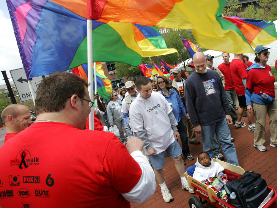 Third Place, Feature Picture Story - Chris Russell / The Columbus Dispatch Bryce has his eyes on the tunnel of brightly colored gay pride flags as he is pulled in his wagon through the Annual Aids Walk in downtown Columbus.  