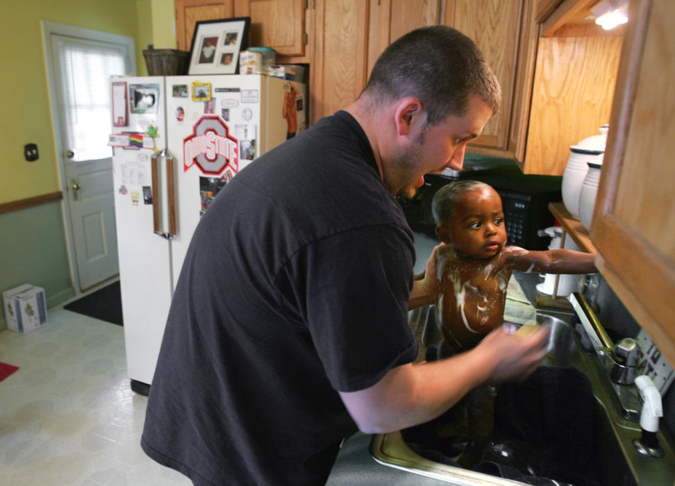 Third Place, Feature Picture Story - Chris Russell / The Columbus DispatchJim uses the kitchen sink to bathe Bryce because it is the right size and the perfect height.  The family lives in a close knit working class neighborhood in Columbus. 