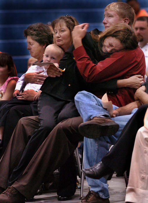 Award of Excellence, General News - Ernest Coleman / Cincinnati EnquirerDarlene Williams sits in the lap of her brother, Craig O’Bannon for support during a Memorial Service for her husband, Spc. Ronnie “John Boy Williams”, who was killed in Iraq when his tank fell into a water-filled ravine, drowning him. The two and other family members take part in the Memorial at Summit View Middle School in Independence, KY on July 23, 2005. On the left is her mother-in-law, Sherri Williams, her mother, Corinne O’Bannon, and her son, Huston, 2.