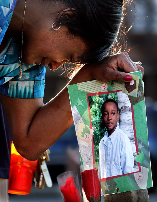 Third Place, News Picture Story - Mike Levy / The Plain DealerTamara Cuevas sister of Brandon Davis grieves at a makeshift memorial on the site where Brandon fell from a fatal gunshot wound in front of the Lonnie Burton Rec Center at Outhwaite.