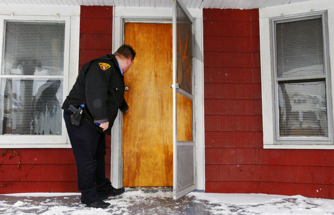 Award of Excellence, News Picture Story - Gus Chan / The Plain DealerHousing court bailiffs never know what will be waiting for them behind the next door.  Al Humphrey checks the door of a house before the movers come to remove the contents of the home.