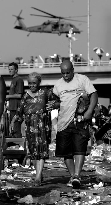 First place, News Picture Story - Dale Omori / The Plain DealerA man assists an elderly woman through the squalor while waiting for a bus to evacuate him from New Orleans in the aftermath of Hurricane Katrina, Sept. 2, 2005.