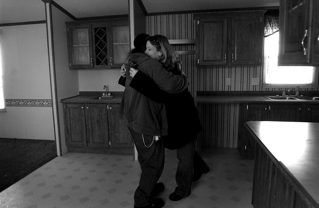 Award of Excellence, News Picture Story - Sung H. Jun / Ohio UniversityTony Mitchell (left) gets a hug from Rebecca Valentine, while they take a look at their new mobile home located in Eastbrook Mobile Home Park. Valentine is happy she can have Christmas at a new home instead of the motel where they have been staying.