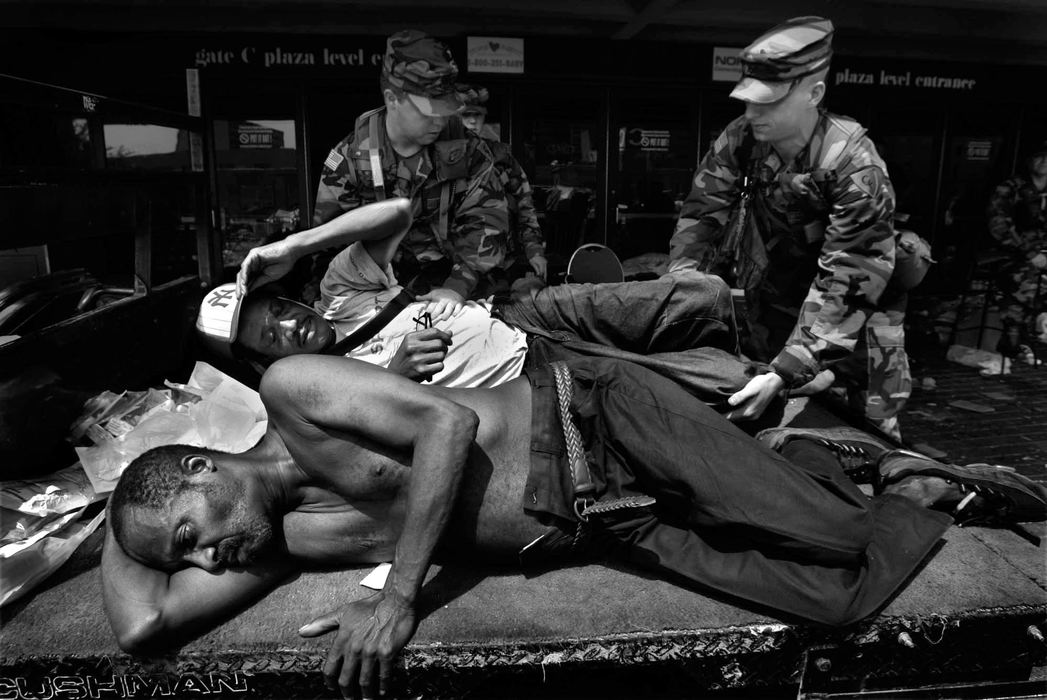 First place, News Picture Story - Dale Omori / The Plain DealerOhio National Guardsmen, staff seargent Dion Brodeur, of Lima, and specialist Joshua Park, of Spencerville,  carry a man to a cart to be taken to a medical infirmary area at the Superdome in New Orleans in the aftermath of Hurricane Katrina, Aug. 3, 2005. 