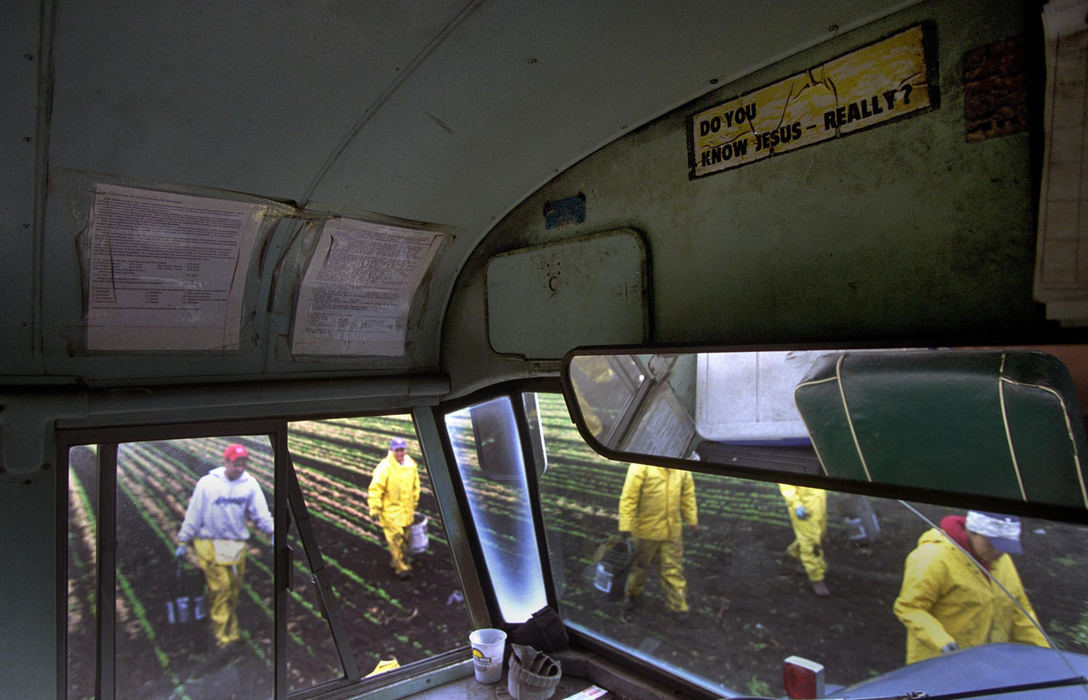 First place, James R. Gordon Ohio Understanding Award - Gary Harwood / Kent State UniversityWorkers return to their bus after weeding by hand and using pails to discard what is removed from the rows. The largest of the crew’s vehicles, the work bus is adorned with stickers and painted statements from previous crews, including the statement about Jesus. Strategically placed, each worker can see it as they exit the bus.