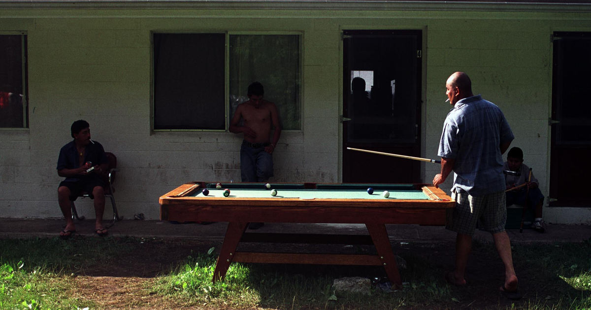First place, James R. Gordon Ohio Understanding Award - Gary Harwood / Kent State UniversityCipriano Contreras plays pool behind his home in Warner camp. The pool table was purchased at a garage sale and was kept outside under plywood and plastic to protect it from the weather. Garage sales, discount stores and the weekly thrift sales at the Migrant Center are popular places for many in the migrant community to shop. 