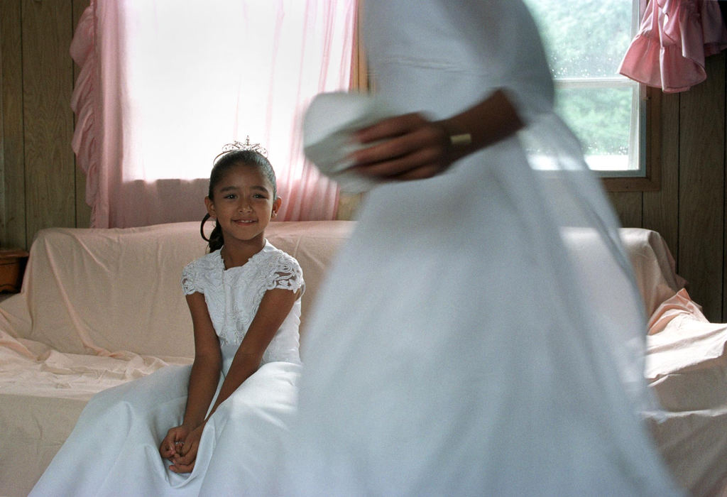 First place, James R. Gordon Ohio Understanding Award - Gary Harwood / Kent State UniversityJasmine Mata waits patiently while her sister, Melissa, gets ready for their first communion. While the children were preparing for their big day, their grandfather was preparing his van for a cross-country trip to Texas. His work on the farm was done, but he stayed for their communion. 