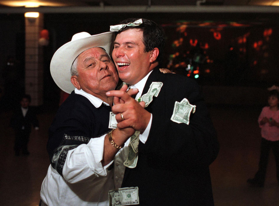 First place, James R. Gordon Ohio Understanding Award - Gary Harwood / Kent State UniversityDuring a humorous moment, a guest pays to dance with Roberto DeLeon during the reception that followed Roberto’s marriage to Erica Contreras at St. Bernard’s Church in Akron. During the traditional money dance, money is pinned to the bride and groom before guests get to dance with them.