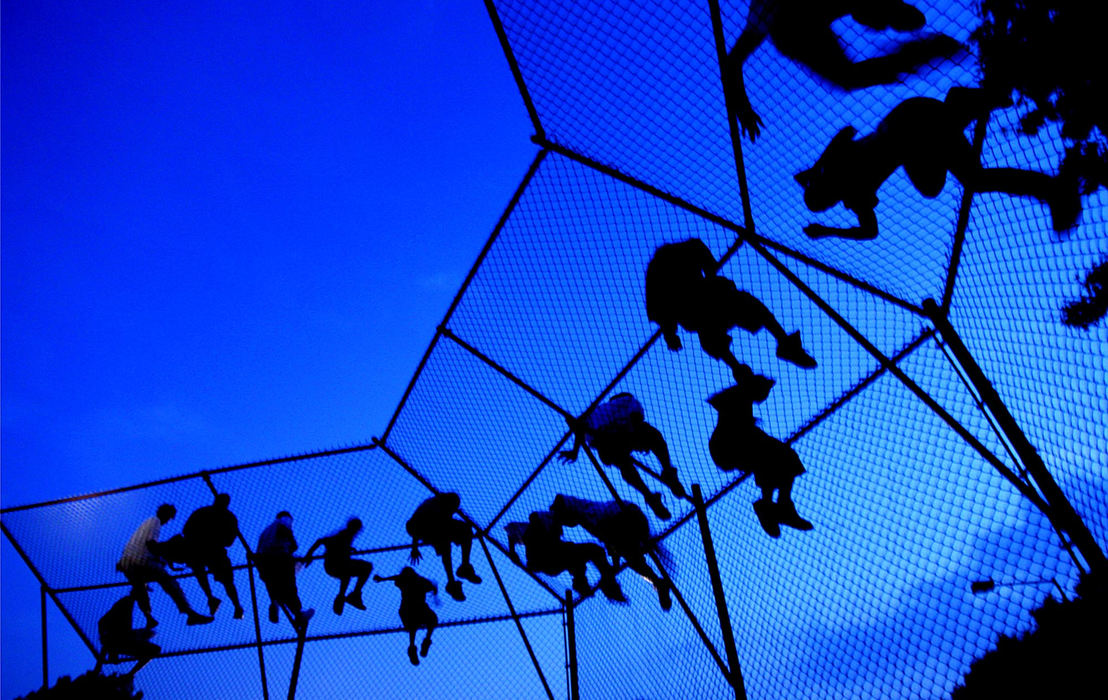 Award of Excellence, Pictorial - Ken Love / Akron Beacon JournalThese fans climbed a baseball batting cage to try to get a better view of  LeBron James at Perkins Park, July 17, 2005. MTV was in town to host the reality TV show Battleground at Perkins Park hosted by LeBron James.  These fans along with thousands of other fans crowded the park for the event.  The police kicked these kids off the batting cage for safety reasons shortly after they climbed on the cage Sunday.   