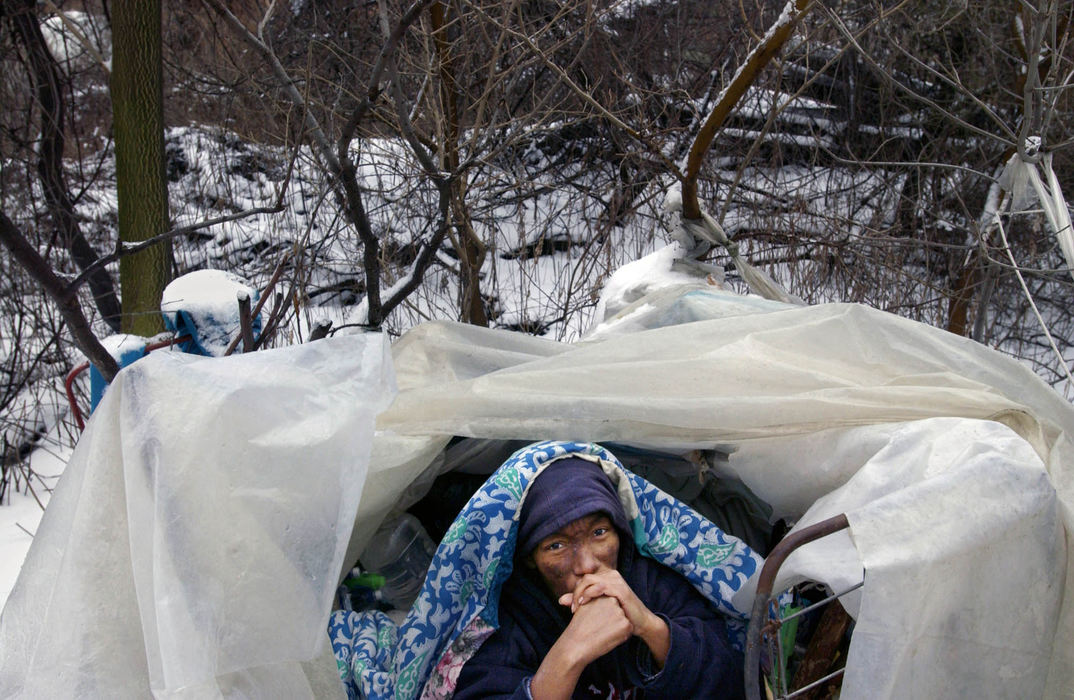 Third Place, George S. Smallsreed Photographer of the Year Award - Gus Chan / The Plain DealerJean, a homeless woman who lives by the E. 55 St. railroad tracks, is one of many people Bill Hahn delivers food, books, and blankets to.  She was photographed at her tarp draped domicile, January, 6, 2005.