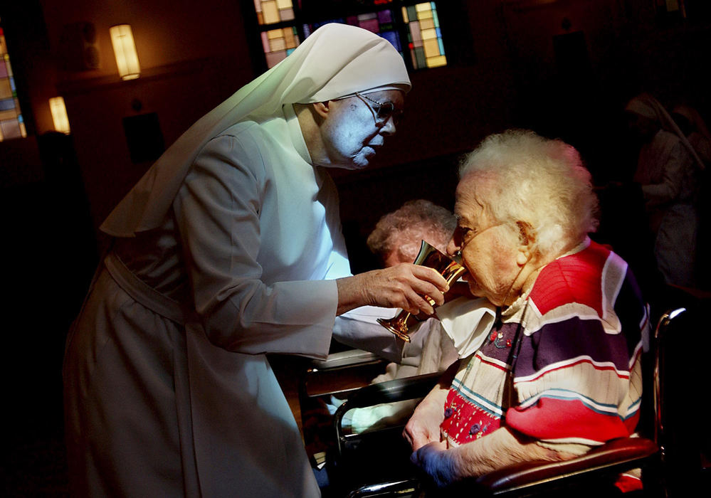 Second Place, George S. Smallsreed Photographer of the Year Award - Greg Ruffing / FreelanceSister Regina helps resident Anna Mudry with Communion at the daily 11a.m. Mass at the Little Sisters of the Poor home in Pittsburgh. The nuns provide 24-hour hands-on care for 60 residents, age 70 to 100, who may not otherwise be able to afford a nursing home, hospice or other type of care. The Little Sisters of the Poor home was founded in Pittsburgh in 1872 to serve the elderly poor, nurture spirituality and assist the dying.