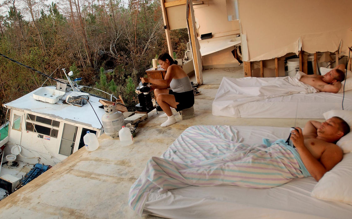 Second Place, George S. Smallsreed Photographer of the Year Award - Greg Ruffing / FreelanceJimmy Goodman (foreground) tunes into a small radio in hopes of getting news about the hurricane while staying with his brother Eric (background right) and mother Joanna Dubreuil (background left) in the remnants of a room at a heavily-damaged motel after their home in Waveland, Miss., was destroyed. 