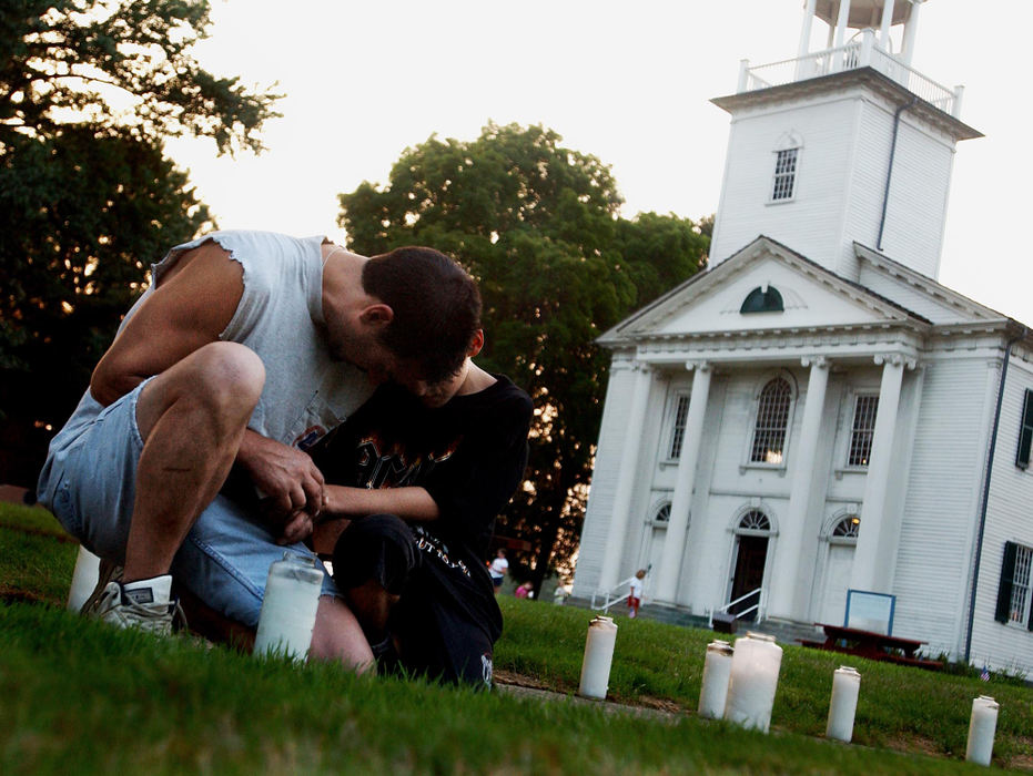 Second Place, George S. Smallsreed Photographer of the Year Award - Greg Ruffing / FreelanceKen Kelsch and his son, Ken Jr., age 8, pray together in the historic Tallmadge Circle for Lance Cpl. Daniel Nathan Deyarmin Jr., his family and other Marines from the 3rd Battalion, 25th Regiment, including one of Mr. Kelsch's former co-workers. They stopped by the town to pray as villagers set out hundreds of candles and luminaries on the circle the evening before Deyarmin's funeral. 