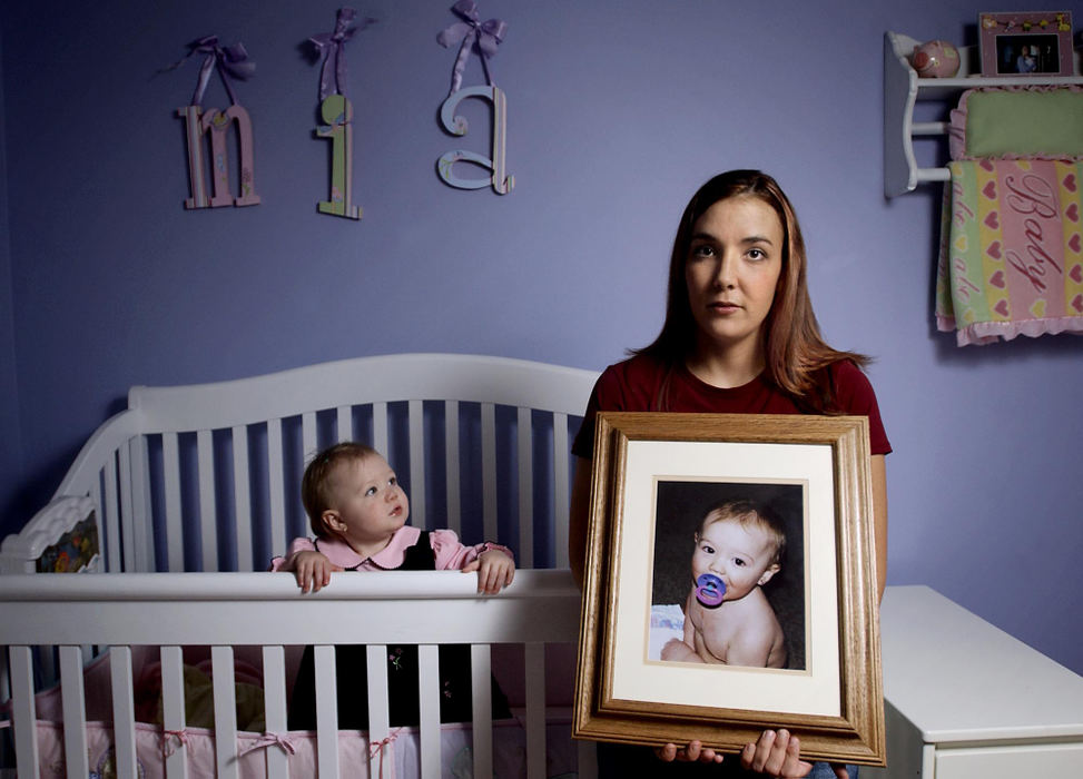 Second Place, George S. Smallsreed Photographer of the Year Award - Greg Ruffing / FreelanceKathy Callahan of Parma Heights, holds a photo of her daughter Isabella, who died unexpectedly and without explanation at age 16 months, in a rare case of Sudden Unexplained Death in Childhood. The diagnosis is similar to Sudden Infant Death Syndrome (SIDS) except that SIDS only applies to children who die at less than 12 months old. In the baby crib at left is her new daughter Mia, who recently turned one year old.