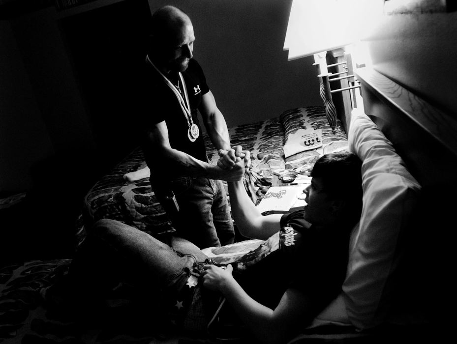 Second Place, George S. Smallsreed Photographer of the Year Award - Greg Ruffing / FreelanceBack in their hotel room and away from the crowds, Willie (wearing his gold medal and a bronze medal he earned in right-hand competition) consoles his son Boomer after he came up short in defending his World Championship gold medal from last year. "No matter what happened today Boomer, I'm proud of you," he said.