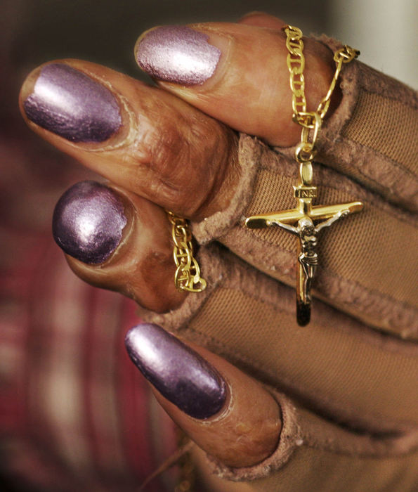 Third Place, George S. Smallsreed Photographer of the Year Award - Gus Chan / The Plain DealerMaria Olmeda, wearing pressure gloves, holds the crucifix she was wearing when she was attacked last March.  Olmeda was burned when she was set on fire by a neighbor who thought Olmeda was having an affair with her husband.  The husband didn't exist.  