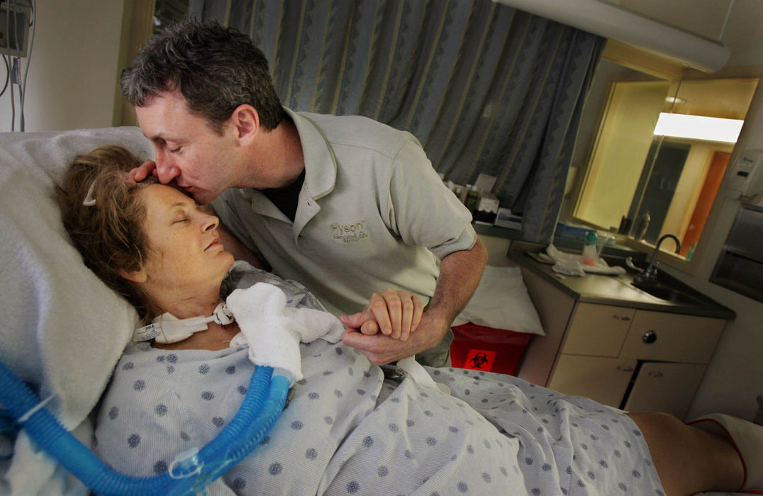 Third Place, George S. Smallsreed Photographer of the Year Award - Gus Chan / The Plain DealerSteve Reilly gives his wife, Nanette, a kiss in the MetroHealth Intensive Care Unit, September 19, 2005.  Nanette was admitted September 3rd after a jet ski accident. 