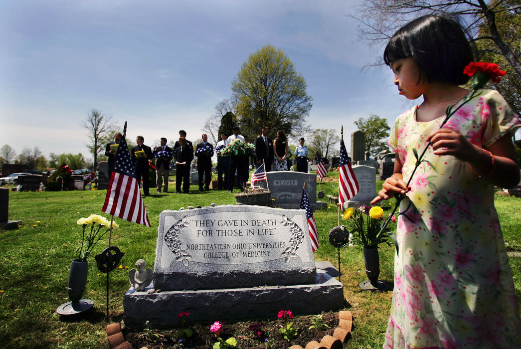 Third Place, George S. Smallsreed Photographer of the Year Award - Gus Chan / The Plain DealerThe Northeast Ohio Universities College of Medicine holds a memorial service for families and friends of the cadavers dissected during first-year anatomy class. Rachel Hardy, 8, of Wadsworth, looks over the headstone at Homeland Cemetery in Rootstown, where the remains of her grandmother, one of this years body donors, is buried.