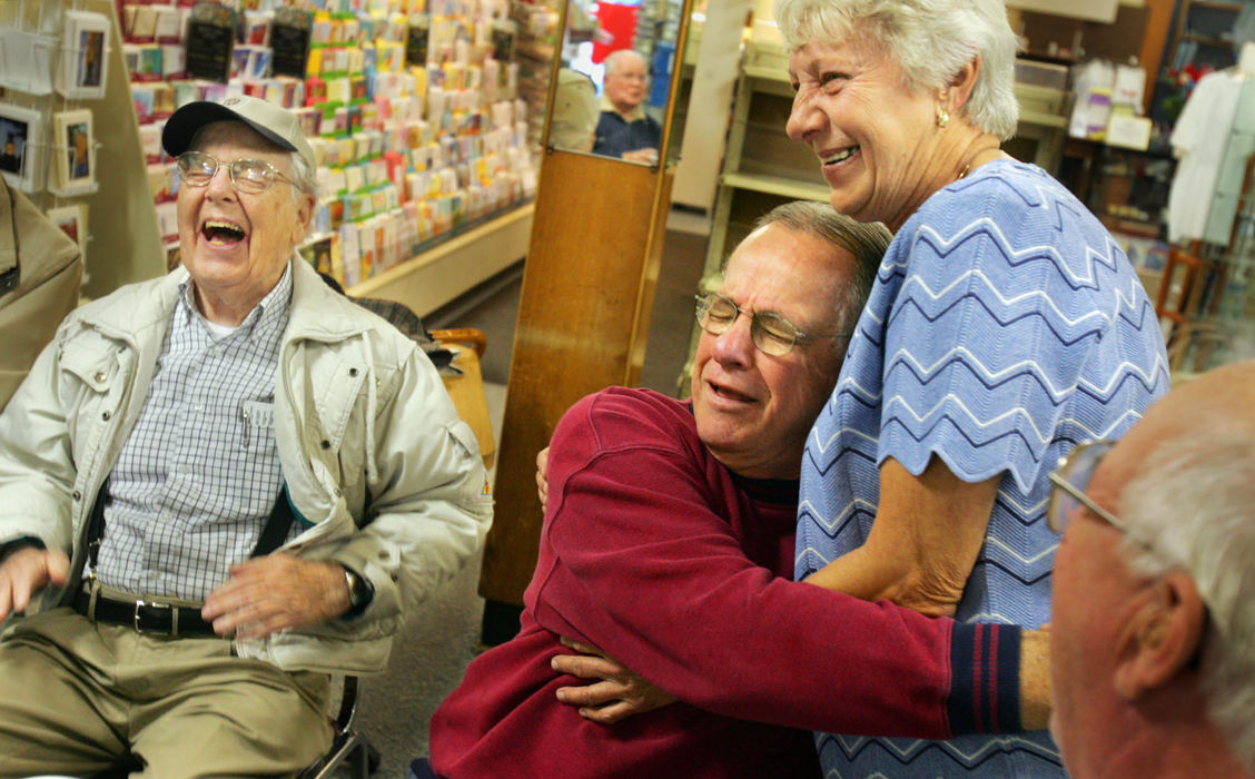 Third Place, George S. Smallsreed Photographer of the Year Award - Gus Chan / The Plain DealerGeorge Janik (center) cries a few fake tears as he gives a hug to longtime Saywell Drug Store worker Mary Ann Howe, October 25, 2005.  The "Wisdom Club" presented Howe with a card and gift for Howe's years of service to the local coffee klatsch.  Sharing in the ceremony is Irv Musson (left) of Akron.  