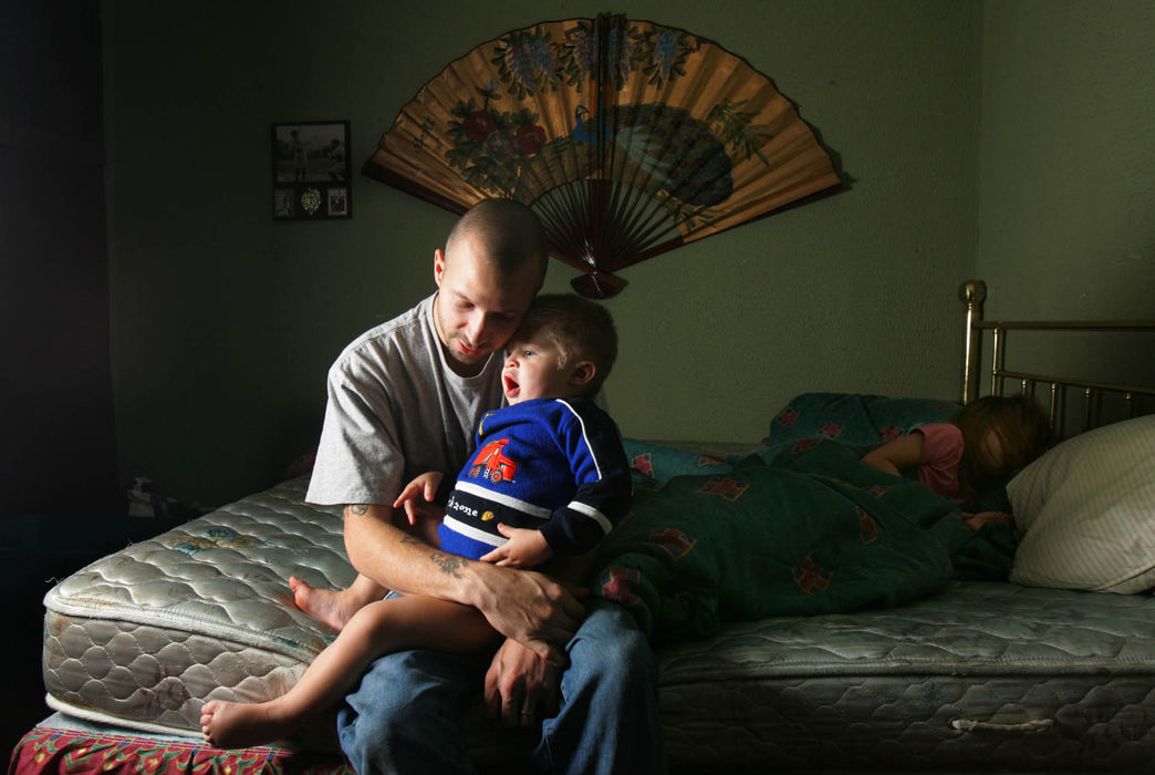 Third Place, George S. Smallsreed Photographer of the Year Award - Gus Chan / The Plain DealerAndy Susak holds his son Jason, 2, while daughter Brittany, 6, finishes her nap. Susak and his wife, Tina, have six children, five of them with special needs. 