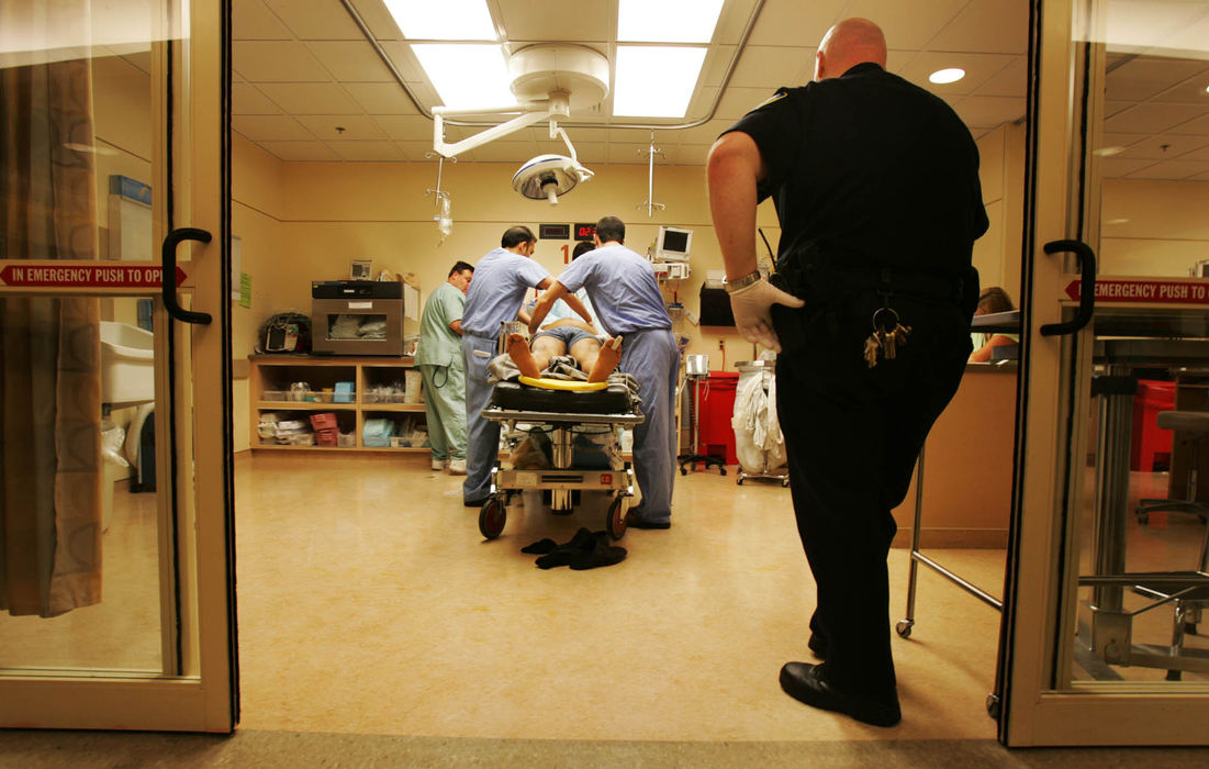 Third Place, George S. Smallsreed Photographer of the Year Award - Gus Chan / The Plain DealerMetroHealth's Emergency Department is the busiest in the city, handling the most traumatic cases in northeastern Ohio. A security officer watches as a patient is being treated.