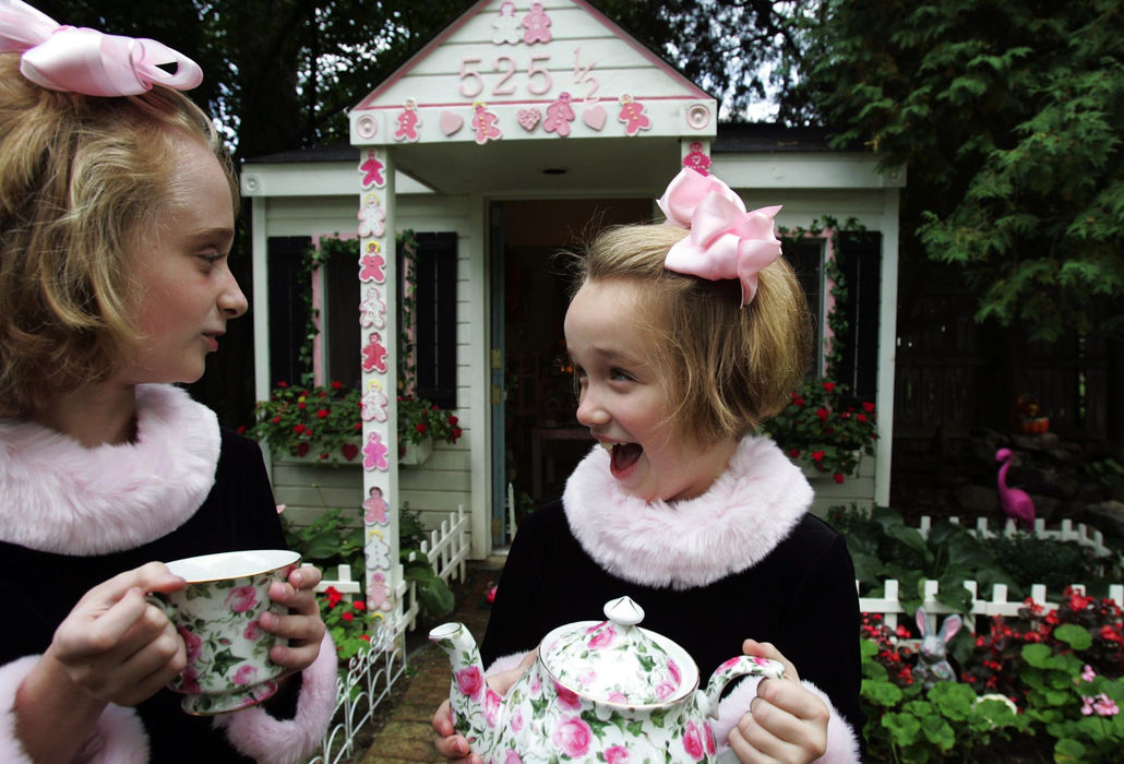 First Place, Portrait/Personality - Emily Rasinski / Kent State UniversitySisters Suzie, 9, and Sarah Shriber, 7, show off the garden tea house in their backyard. The house changes themes to suit their interests.   