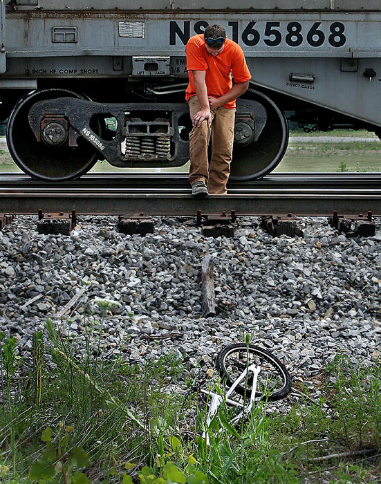 Second Place, Spot News over 100,000 - Lisa Dutton / The BladeToledo Edison employee Nick Lyon pauses at the scene of the fatal train accident that killed an 11-year-old boy riding his bike across the tracks. Lyon was the first person to reach the boy.
