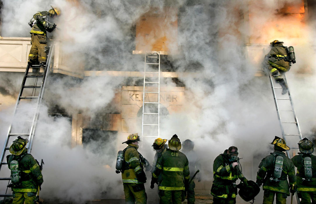 Award of Excellence, Spot News over 100,000 - David I. Andersen / The Plain DealerCleveland fire fighters disappear into the smoke as they cut holes into the boarded-up abandoned building at W. 97th St. and Lorain Ave. in Cleveland.  A body of a homeless woman was found after the triple three alarm fire was put out.