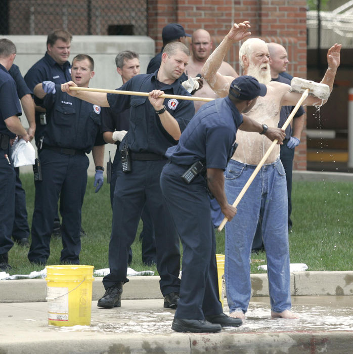 Award of Excellence, Spot News over 100,000 - Mike Munden / The Columbus DispatchColumbus firefighters decontaminate of one of several construction workers who were affected by the chemical spill or cloud on the OSU campus. The workers were working at the OSU power plant on a new boiler when the accident occurred, they did not cause the accident but did breathe in some of the chemical.