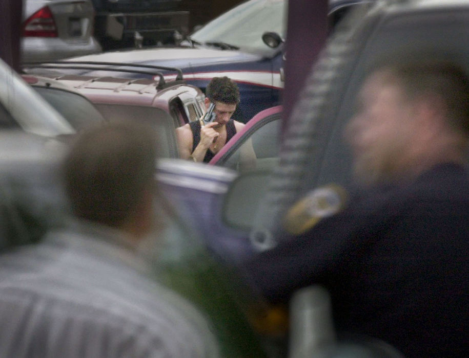 Third Place, Spot News under 100,000 - Dave Polcyn / Mansfield News JournalThomas Wynn holds a gun to his head threatening to kill himself during a standoff in a strip-mall parking lot in Mansfield. Wynn gave himself up after 11 hours. He is accused of murder and car jacking before the standoff began.