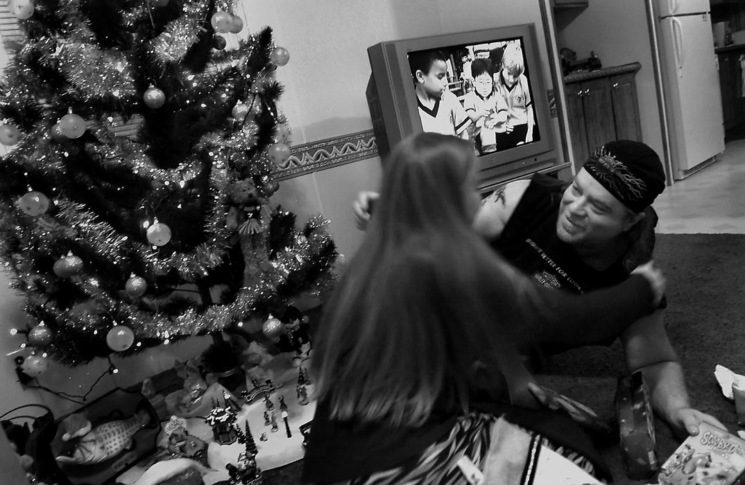 Award of Excellence, Student Photographer of the Year Award - Sung H. Jun  / Ohio UniversityTony Mitchell enjoys Christmas Eve with his family including his daughter, Tiffany Mitchell (left) at his new home in Eastbrook Mobile Home Park. Tony received a Scooby-Doo DVD from Tiffany, who was visiting from California. Scooby-Doo was Tiffany's favorite childhood TV program. 