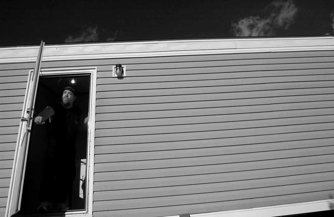 Award of Excellence, Student Photographer of the Year Award - Sung H. Jun  / Ohio UniversityTony Mitchell looks outside through the side door of his new mobile home in Eastbrook Mobile home. Mitchell survived the Nov, 6th tornado thanks to his canopy bed which prevented the roof of his mobile home from crushing him. "I'm 46 years old," Mitchell said. "Before the tornado, this was a beautiful trailer park. It seemed like it was out of the movies. I know it will be beautiful again."