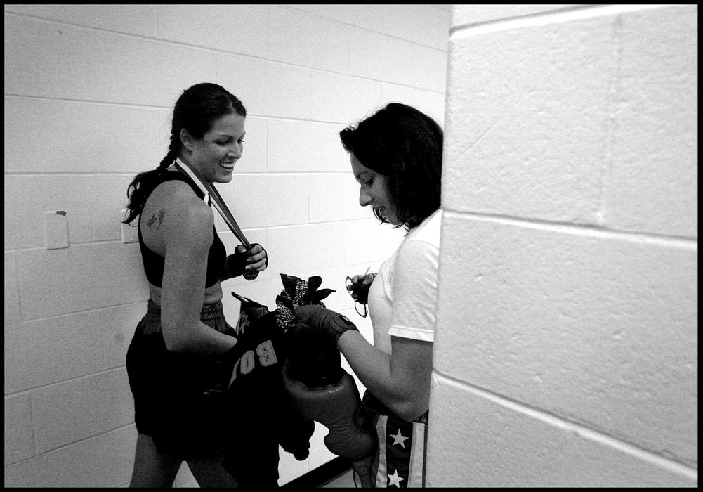 First place, Student Photographer of the Year Award - Katie Falkenberg / Ohio UniversityAfter the fight, Jessica and Valerie compare their medals in the entryway of the men’s locker room. They are long-time opponents at fights, but good friends outside of boxing. Whenever there are fights in areas near the towns where they live, they always end up fighting each other because of the lack of other women boxers in the area.