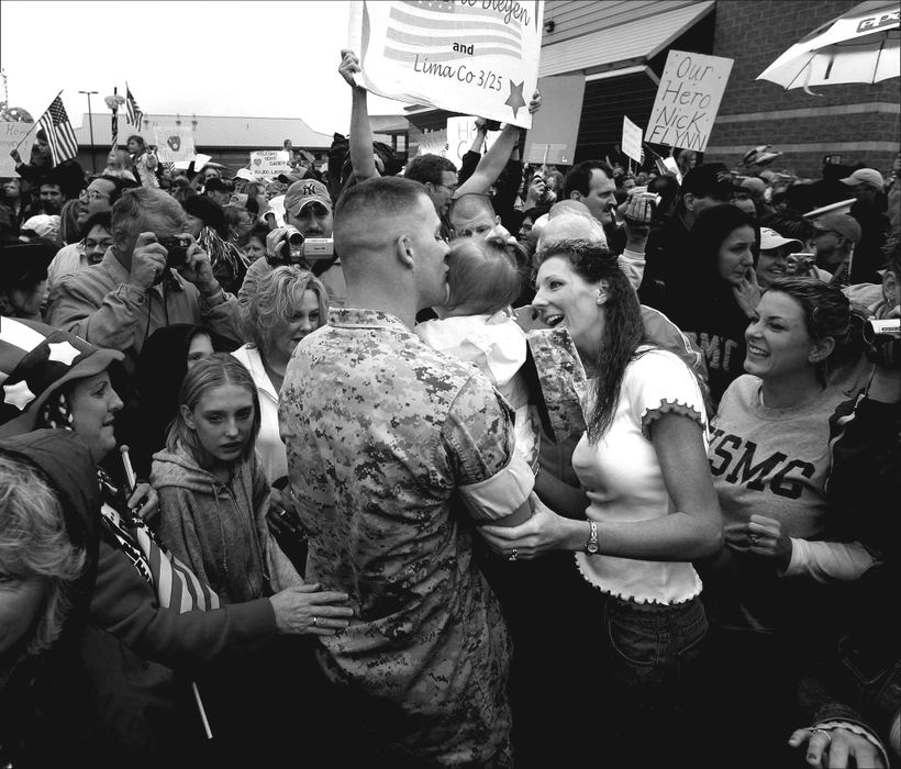 First place, Student Photographer of the Year Award - Katie Falkenberg / Ohio UniversityA father from Lima Company kisses his young daughter as his wife looks on, after arriving home from Iraq in Columbus. Lima Company, part of the 3rd Battalion, 25th Marines, lost 16 reservists in Iraq, including 9 in August, 2005, in the country’s deadliest roadside bombing of U.S. troops. 