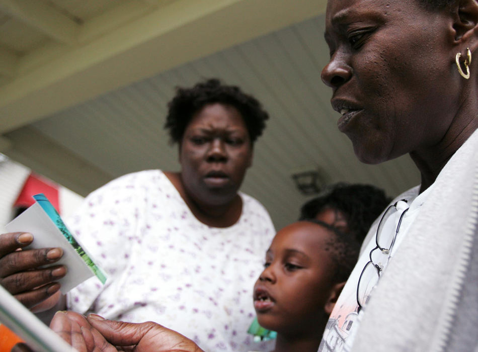 Second Place, Student Photographer of the Year Award - Emily Rasinski / Kent State UniversityLana Green (right) shows her daughter Claudia (left) and her grandkids the photos she took during her trip to New Orleans to look over the damage to their homes.  "It was shocking," she said.  "Ain't nothing good about it. It's never gonna be the same again.  Jesus, life is hard."