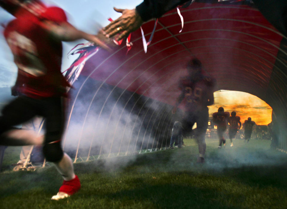 Second Place, Student Photographer of the Year Award - Emily Rasinski / Kent State UniversityManchester football players high-five their coach as they enter the field before their homecoming game.