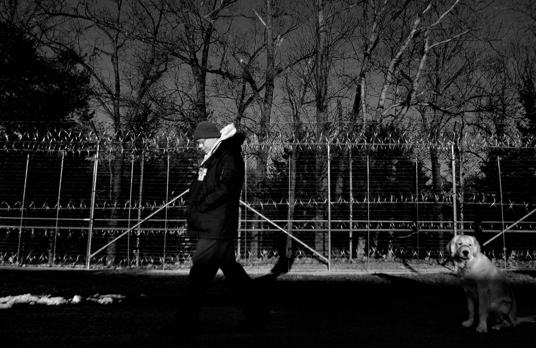 Third Place, Student Photographer of the Year Award - Michael P. King / Ohio UniversityHocking Correctional Facility inmate Richard Miller strolls the prison yard with his dog, Alfie, not far behind on Feb. 18, 2005. Since 1999, Hocking Correctional Facility in Nelsonville has been the only male institution in the United States that raises puppies to be helper dogs for the Canine Companions for Independence Program.