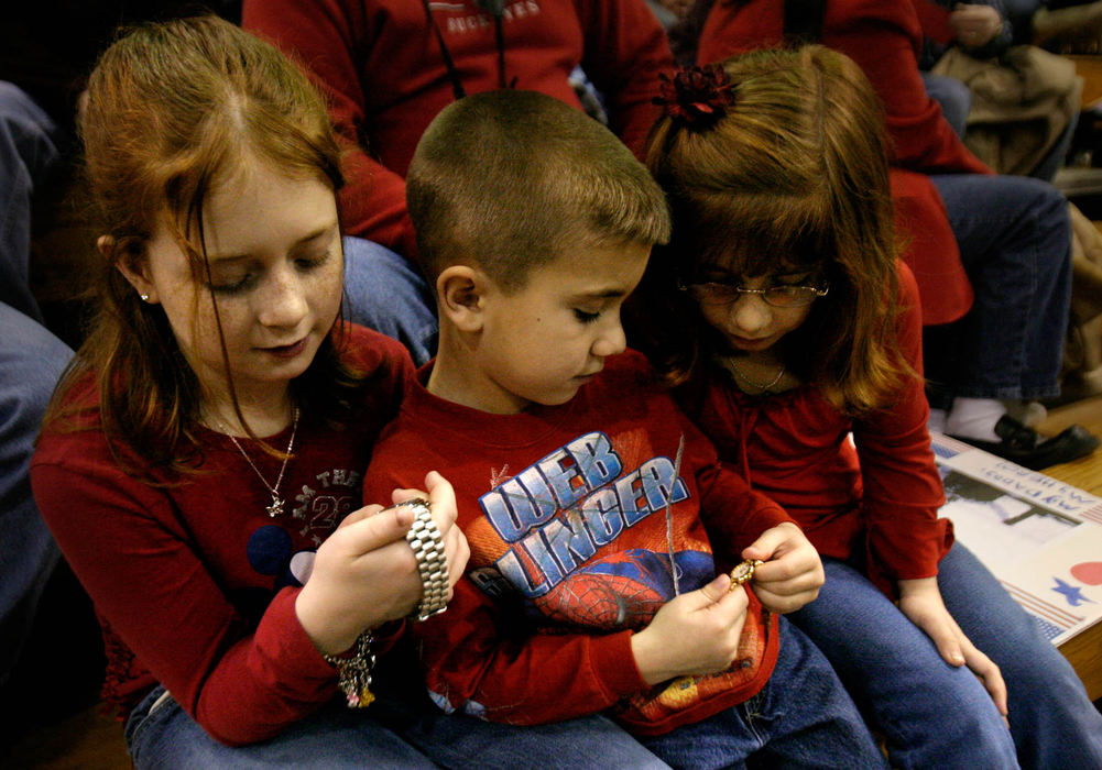 Third Place, Student Photographer of the Year Award - Michael P. King / Ohio UniversityFrom left, Caitlin, 10, Riley, 6, and Kelsey McCabe, 8, wait in the stands of the OU-Chillicothe Shoemaker Center, for the return of their father, Sgt. Mark McCabe of the Ohio National Guard 216th Engineer Battalion Alpha Company. The children were keeping time on family timepieces; the one Caitlin McCabe holds was a gift from her father to her grandfather while stationed in Iraq.
