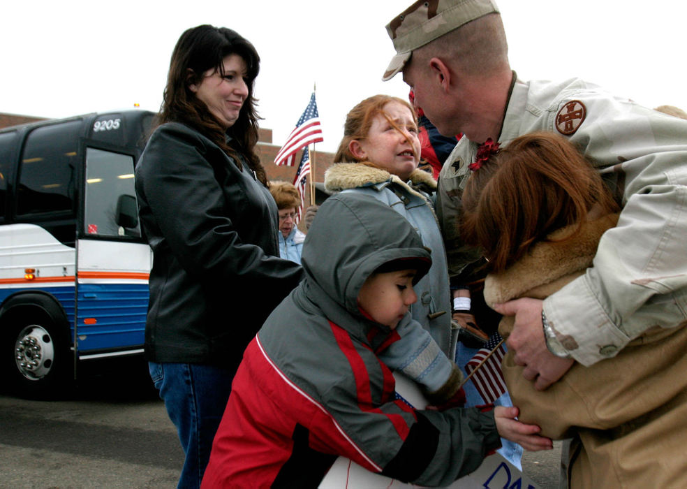 Third Place, Student Photographer of the Year Award - Michael P. King / Ohio UniversitySgt. Mark McCabe, mechanic and combat lifesaver with the Ohio National Guard 216th Engineer Battalion Alpha Company, is reunited with his wife, Tara, and children, from left, Riley, 6, Caitlin, 10, and Kelsey, 8, Feb. 11, 2005 at the Ohio University-Chillicothe Shoemaker Center after a one-year tour of duty in Iraq.