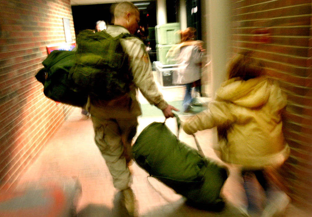 Third Place, Student Photographer of the Year Award - Michael P. King / Ohio UniversitySgt. Mark McCabe gets some assistance with one of his three heavy army duffels from daughter Kelsey, 8, while preparing to finally leave for their home in South Bloomingville.