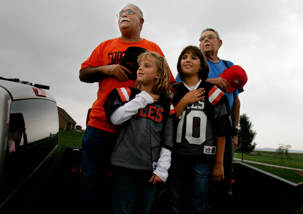 Third Place, Student Photographer of the Year Award - Michael P. King / Ohio UniversityFrom left, James Lutz, Hayley Neff, 9, Josie Dupler, 9, and Leland Dupler, all from Amanda, stand for the national anthem while watching a high school football game from the bed of Lutz's pickup truck outside the fence of Amanda Clearcreek High School, Aug. 26, 2005.